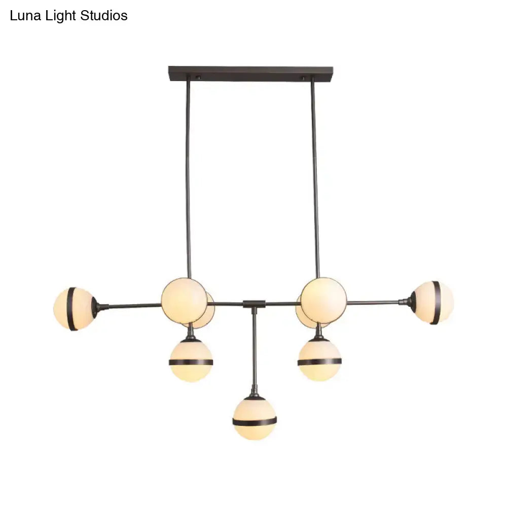 Modern black metal orb chandelier with six frosted glass globe shades and silver gold finish bulb base for restaurants and hotels