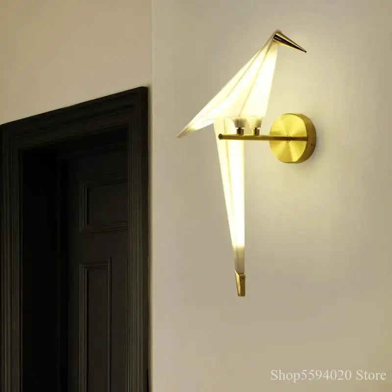Modern gold origami bird led wall lamp with translucent panels emitting warm light for bedroom or living room