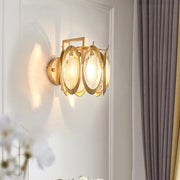 Modern gold oval crystal wall light with circular glass shades and gold-toned metal as elegant living room wall light fixture
