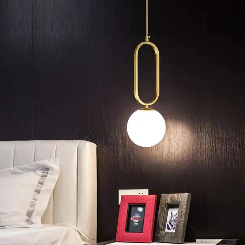 Modern gold oval glass ball pendant light features a gold-toned frame and frosted glass globe ideal for dining room decorbites pendant lights