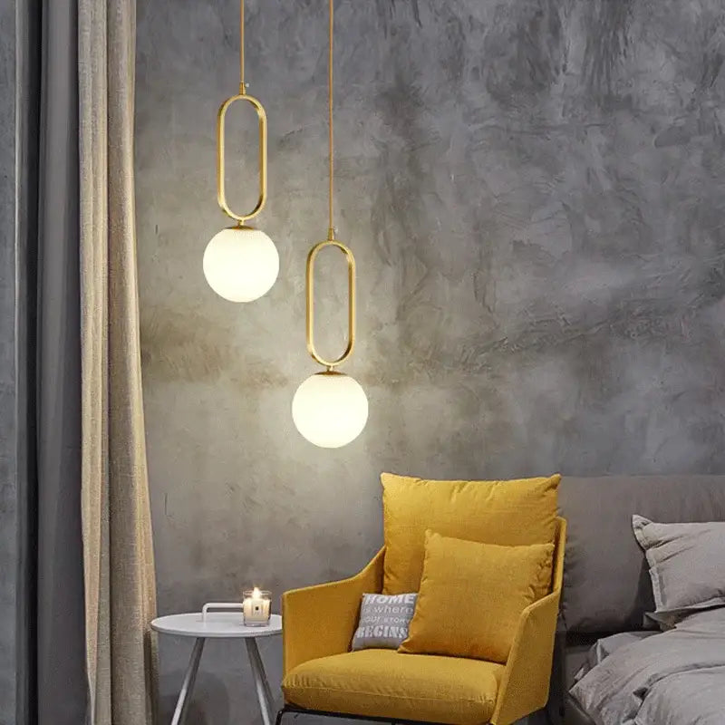 Two modern pendant lights with gold-toned metal frames and white glass ball shades for dining room decorbites glass ball