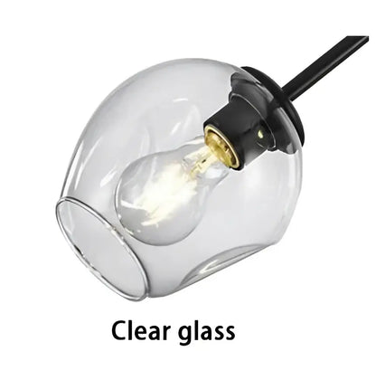 Modern gold painted metal pendant light with clear glass globe and visible filament bulb for dining room use
