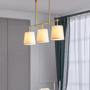 Decorbites™ modern gold pendant lamp with three gold-toned brass lights and off-white fabric shades for dining rooms
