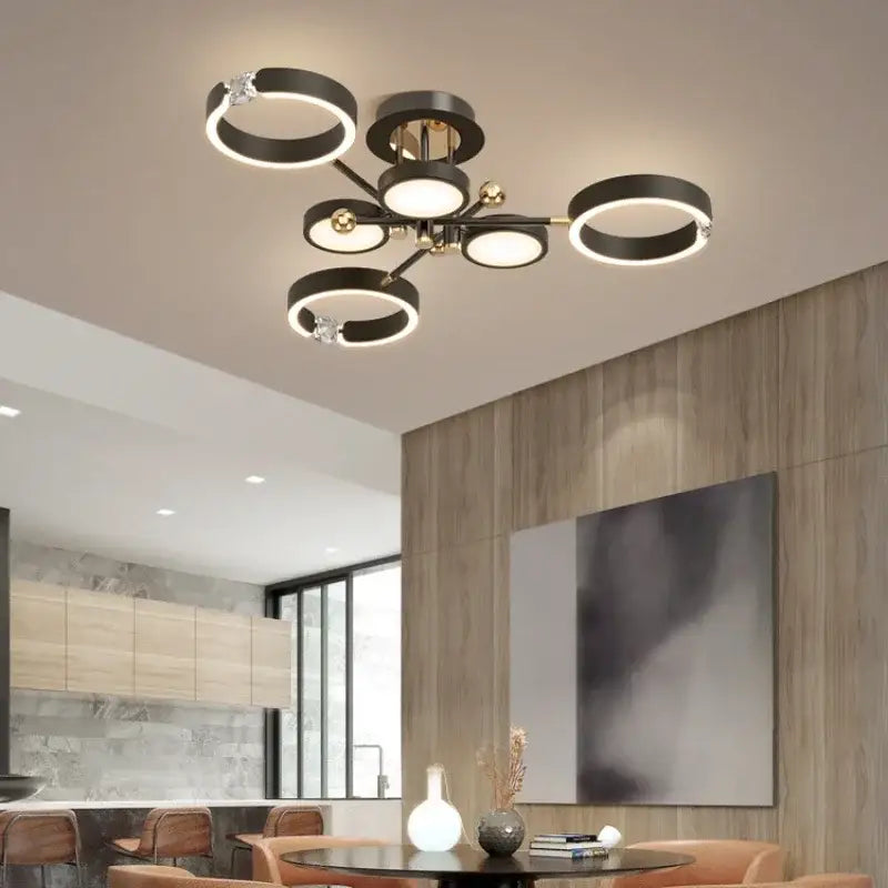 Modern gold plated chandelier with black arms featuring illuminated black and gold circular rings for living room decorbites gold plated