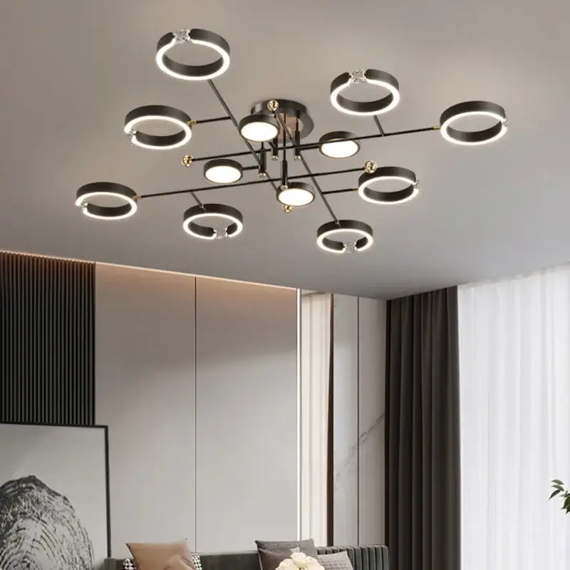 Modern black and gold plated chandelier with glowing circular lights and black arms for living room decorbites gold plated