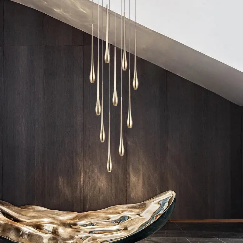 A modern gold-plated led chandelier with slender teardrop fixtures cascading in a living room decorbites gold-plated led