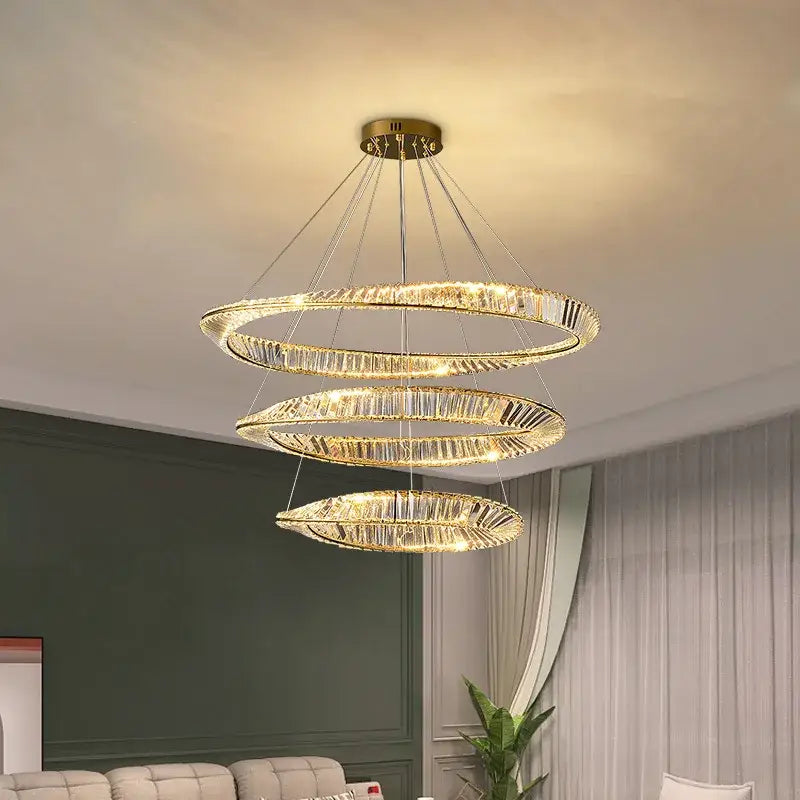 Modern gold plated steel pendant lamp with three-tiered cascading crystal rings emitting warm glow for dining room decorbites gold plated