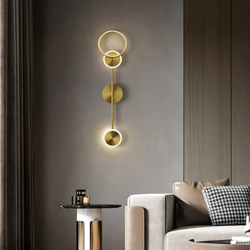Modern gold plated three disc led wall lamp with gold toned rings emitting warm glow for bedroom decorbites gold plated