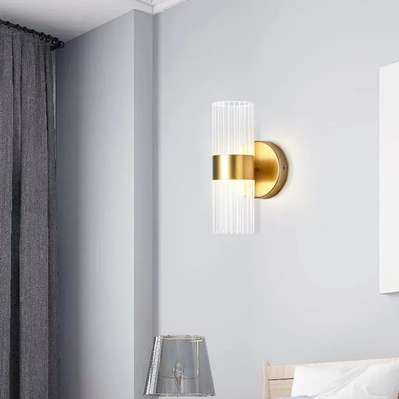 Gold-finished wall lamp with a modern ribbed glass shade luxury designed for bedroom bedside lighting
