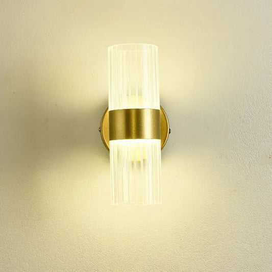 A modern gold wall lamp with clear ribbed glass shade luxury designed for bedroom bedside use