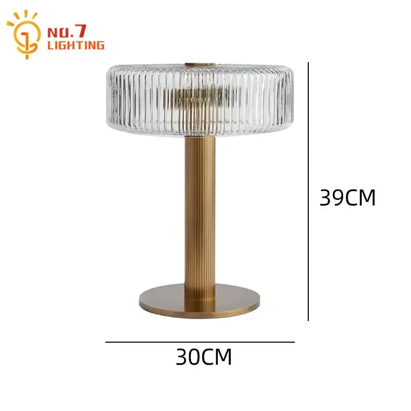 Modern gold ribbed glass table lamp with a clear glass shade and brass-finished base for bedroom decorbites glass table lamp