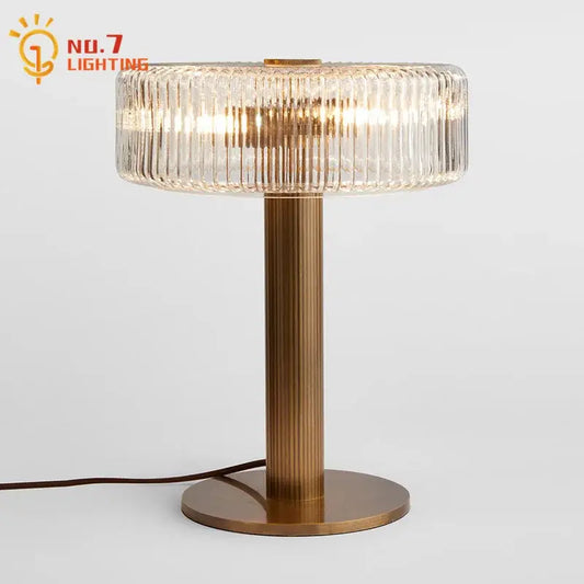 Modern gold ribbed glass table lamp with a metal base and circular ridged glass shade for bedroom decorbites glass table