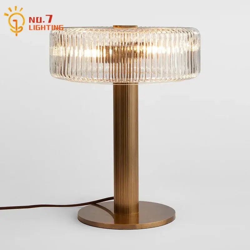 Modern gold ribbed glass table lamp with a metal base and circular ridged glass shade for bedroom decorbites glass table
