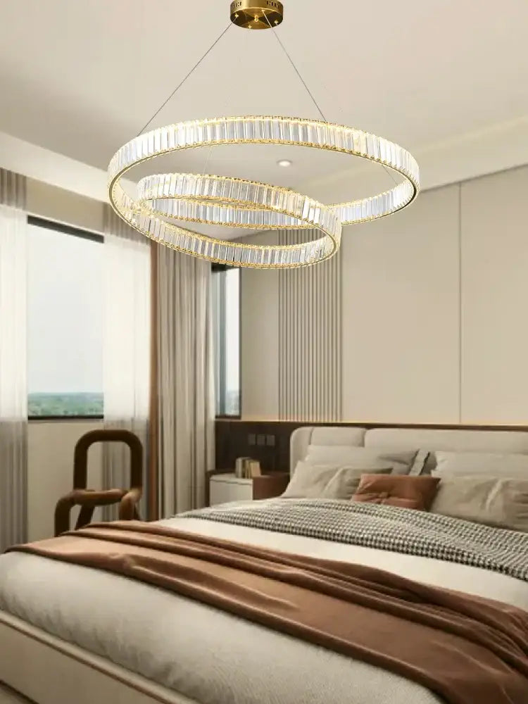 Modern gold ring crystal led pendant light featuring three-tiered circular chandelier with crystal led pendant rods