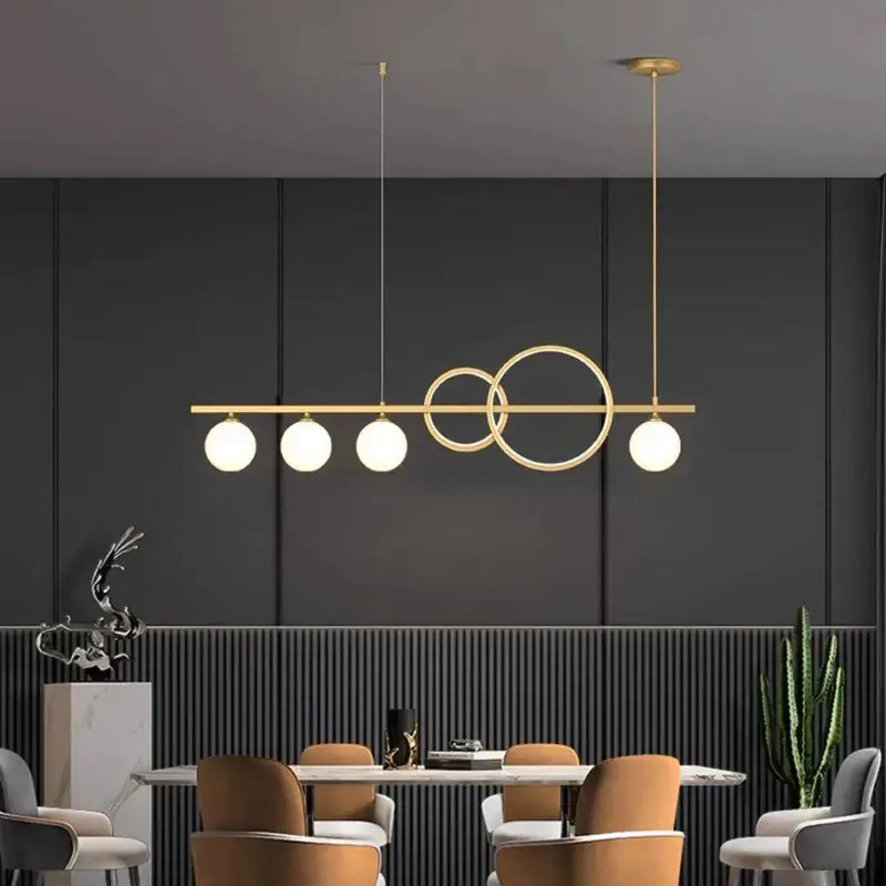 Modern gold-toned pendant light with five spherical bulbs and intersecting rings for elegant chandelier dining decorbites use