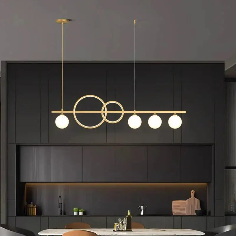 Modern gold-toned pendant light with intersecting circular rings and frosted glass bulbs from decorbites elegant chandelier dining collection