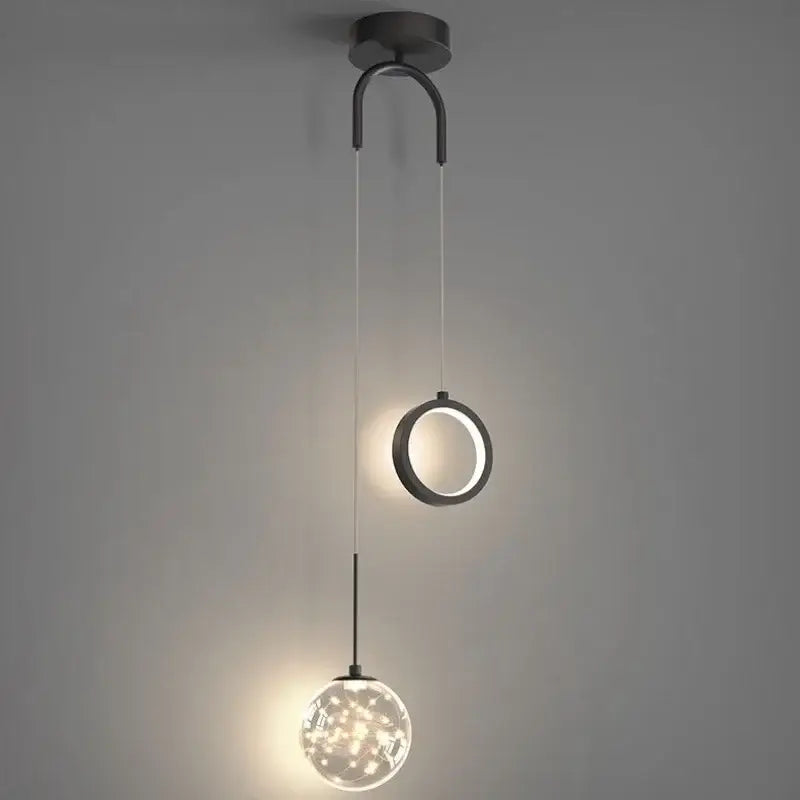 Modern black metal pendant light with circular ring and spherical globe illuminated by warm led decorbites gold ring light
