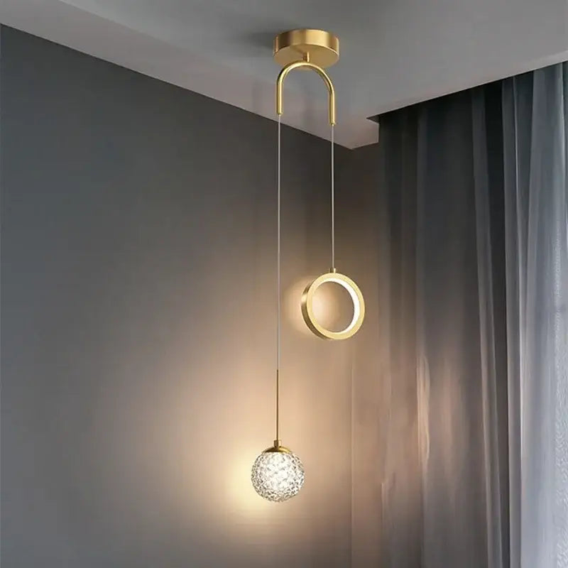 Modern gold ring led pendant light with sleek curved arm, illuminated circular ring, and faceted crystal globe decorbites gold ring
