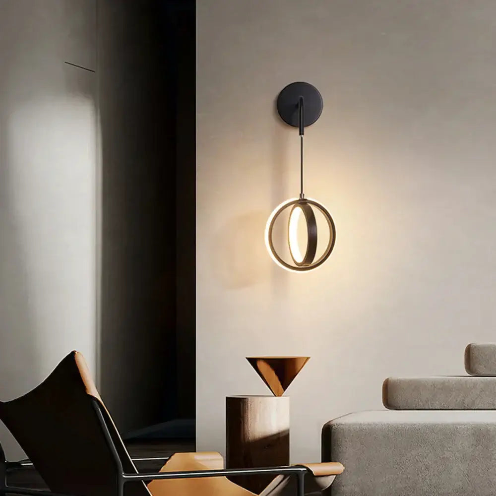 Modern gold ring led wall lamp featuring a black circular design with a glowing gold ring pendant for bedroom and living room