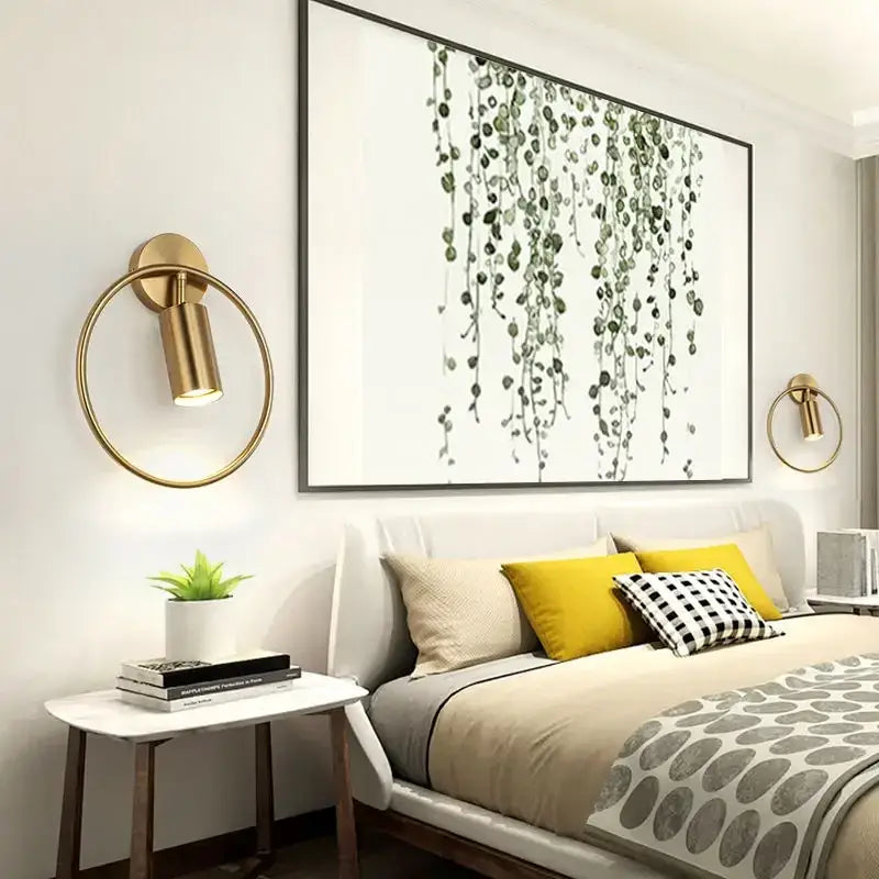 Modern gold ring led wall sconce light with gold-toned circular design and cylindrical lamp head for adjustable bedroom use