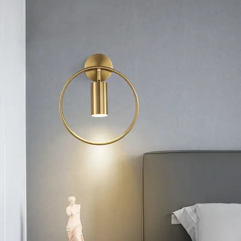 Modern gold ring led wall sconce light featuring a gold-toned circular frame and cylindrical adjustable sconce light fixture