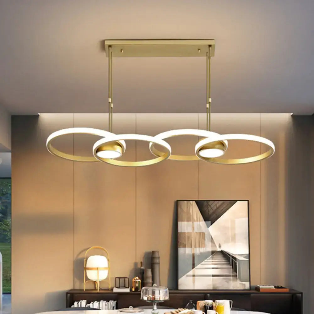 Modern gold ring pendant light with three interlocking circular rings and warm white integrated led bulbs
