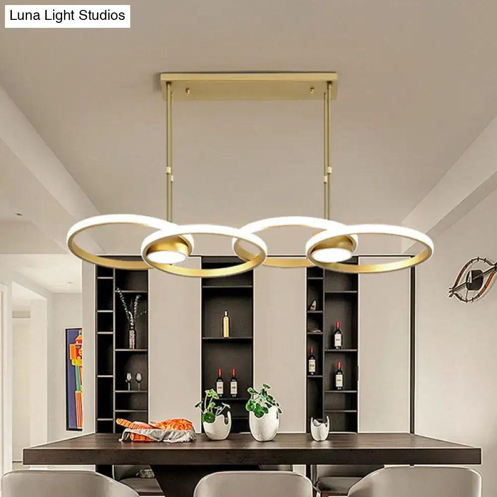 Modern gold ring pendant light with three interlocking circular rings and warm white integrated led bulbs for kitchen use