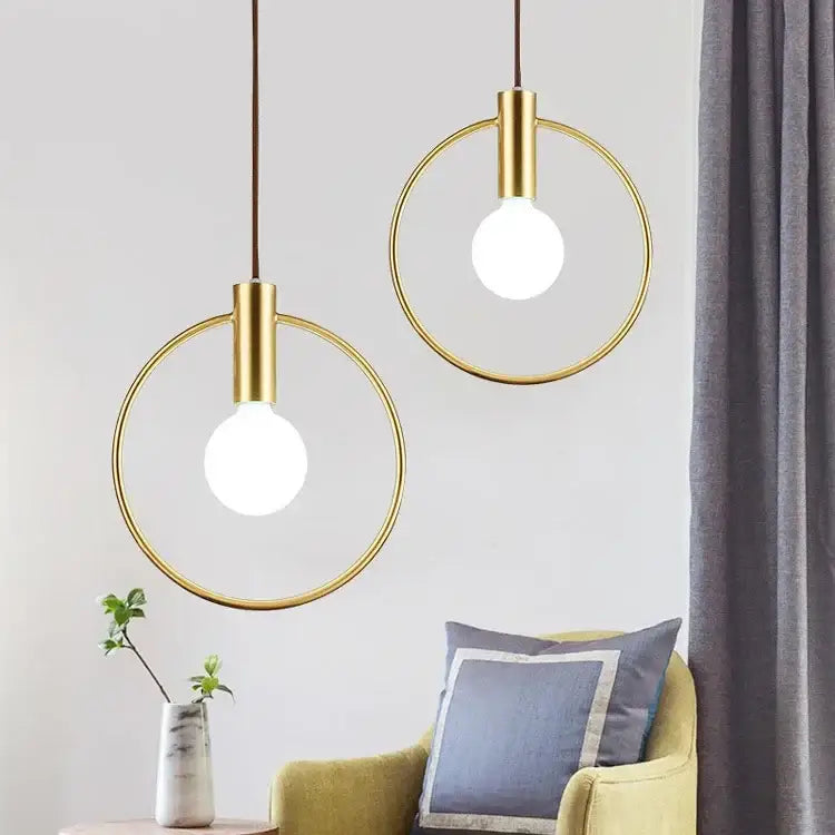 Two modern gold-toned decorbites gold ring pendant light fixtures with exposed bulbs for living room decor