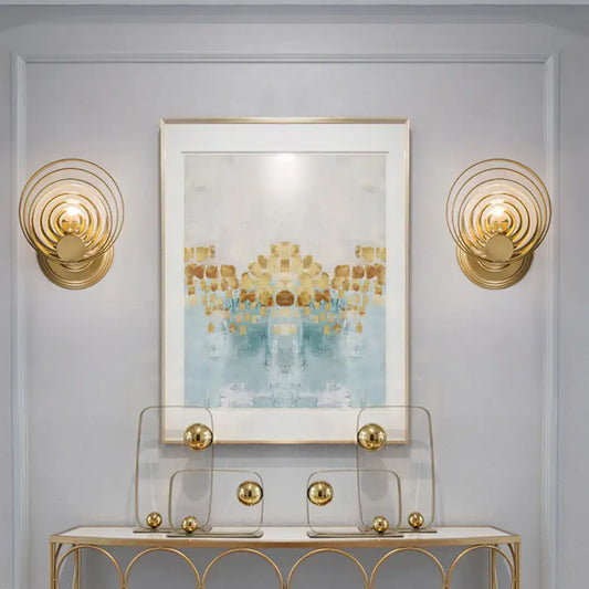 Modern gold ripple glass wall light fixture featuring gold-toned concentric circles for living room use