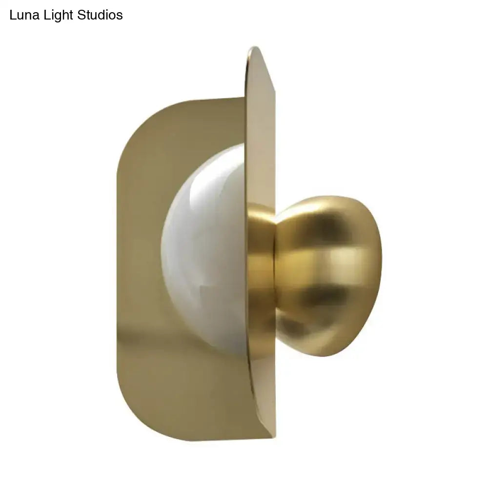 Modern gold sconce light with curved metal shade featuring a sleek curved metal frame and frosted glass bulb for bedroom use