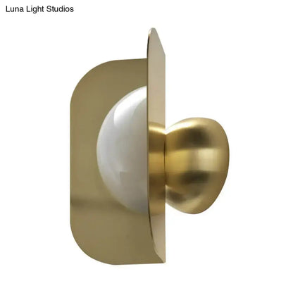 Modern gold sconce light with curved metal shade featuring a sleek curved metal frame and frosted glass bulb for bedroom use