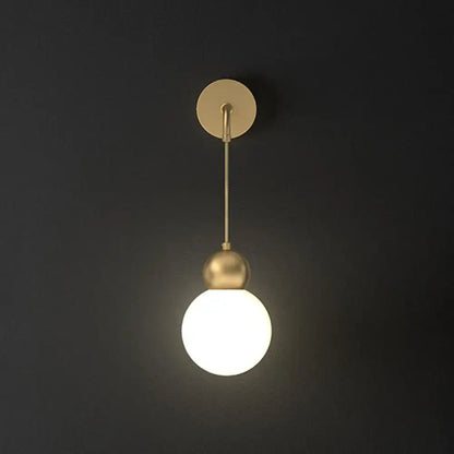 Modern gold sconce light wall lamp with milky glass globe and minimalist metal fixture for bedroom use