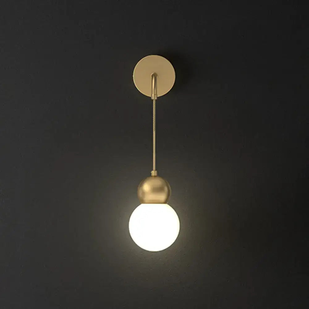Modern gold sconce light wall lamp featuring a gold-toned spherical pendant with milky glass and minimalist fixture