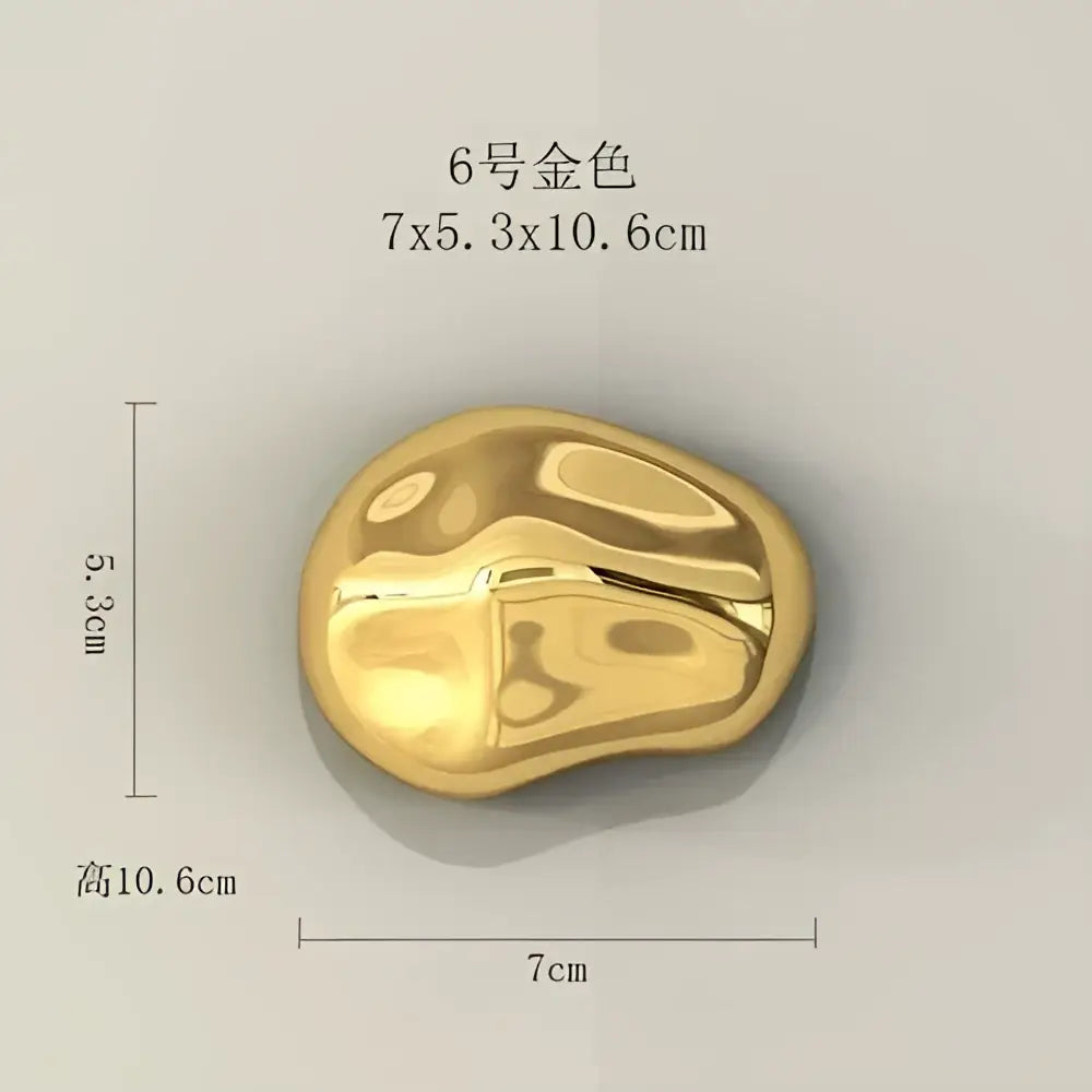 A smooth polished gold stone wall ornament with glossy finish and irregular contours for modern living room decor