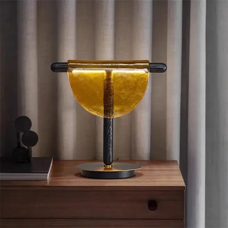 Modern gold and silver amber glass table lamp with semi-circular shade and black textured stem for bedroom decorbites amber glass decor