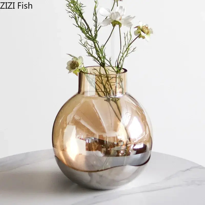 A sleek modern decorbites amber glass vase with rounded body and gold to silver metallic finish for living room decor