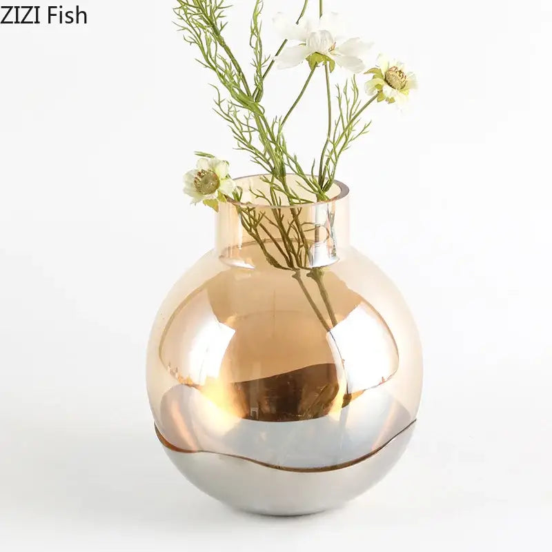 A sleek decorbites amber glass vase with reflective gold upper half and polished silver base for living room decor