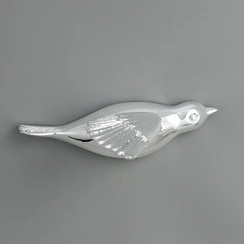 Silver bird-shaped brooch with polished metallic finish and detailed wing engraving for resin statue wall decor
