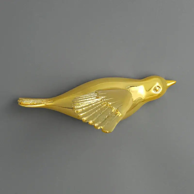 Golden bird-shaped brooch with detailed wing and tail feathers for modern gold and silver bird resin statue wall decor children’s room