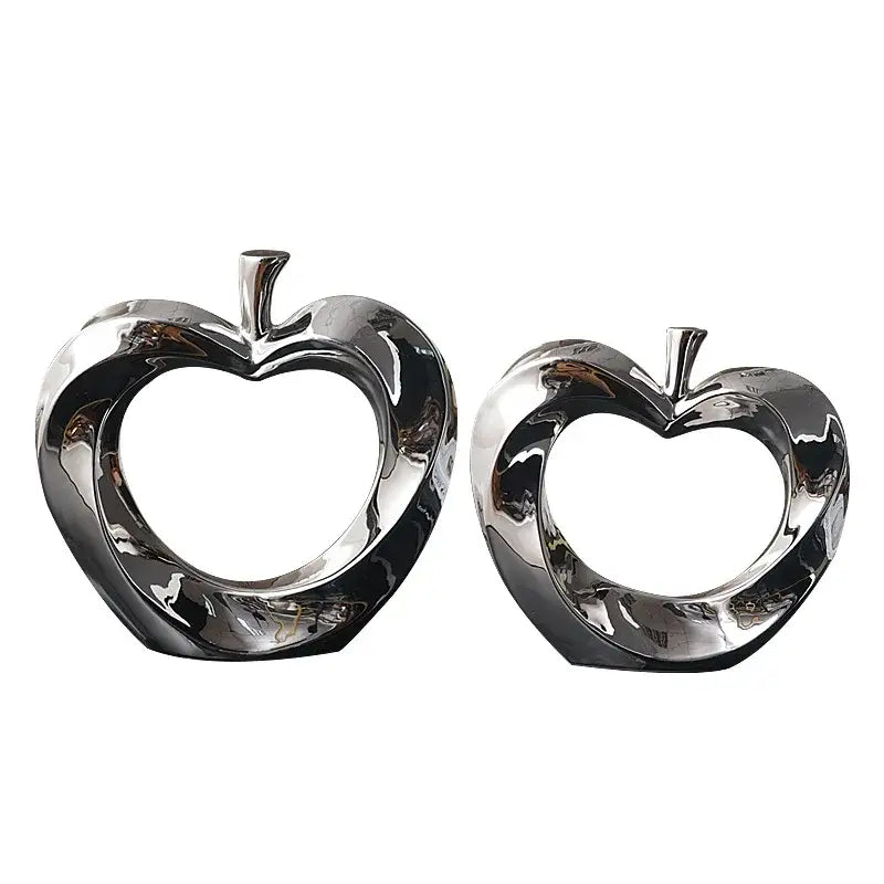 Shiny chrome golden apple sculpture with heart-cutout center and stylized stem for modern living room decor