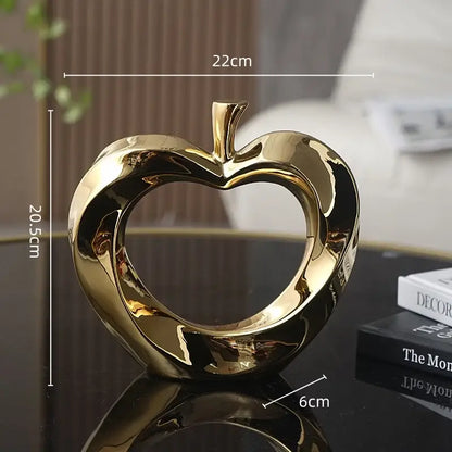 Shiny gold ceramic golden apple sculpture with heart cutout and glossy finish for modern living room decor