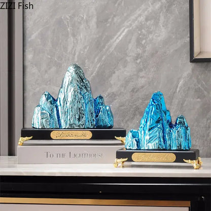 Modern gold and silver ceramic mountain sculpture decorbites with blue glass and gold accents on black bases for living room decor