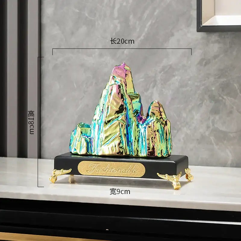 Modern gold and silver decorbites ceramic mountain sculpture with iridescent finish on ornate black base for living room decor