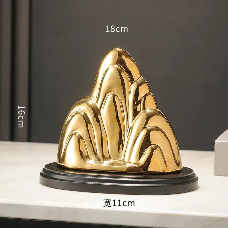 Modern gold and silver decorbites ceramic mountain sculpture with sleek reflective surfaces on a black base for decor