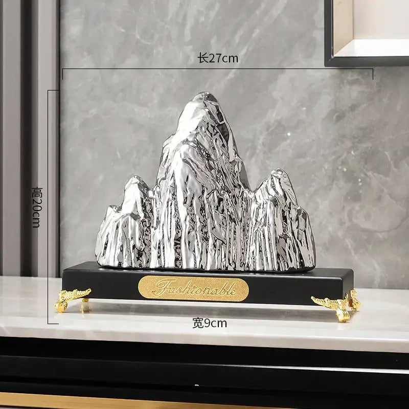 Silver metallic ceramic mountain sculpture with glossy finish on black base with gold feet for modern decorbites mountain decor