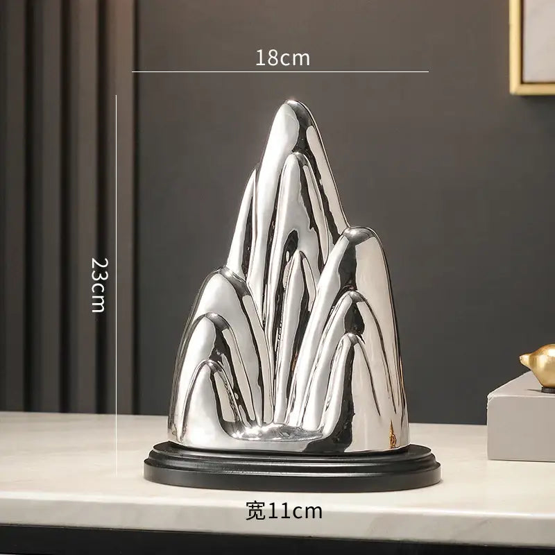 Shiny silver ceramic mountain sculpture with sleek modern design on black base for decorbites ceramic mountain decor