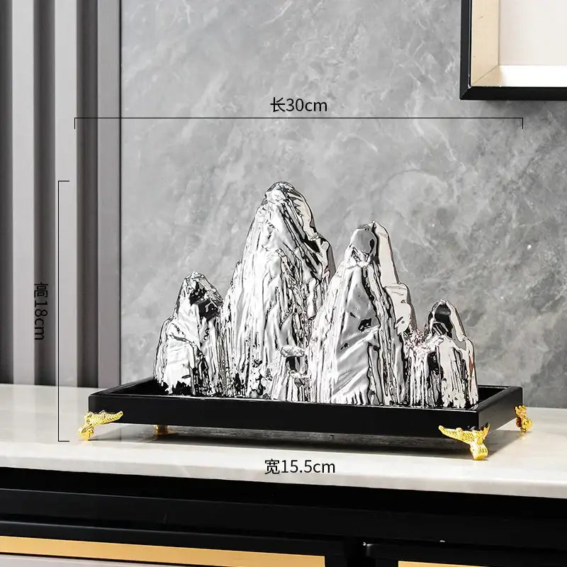 Shiny silver metallic ceramic mountain sculpture on black tray with gold feet modern mountain sculpture decorbites ceramic mountain decor