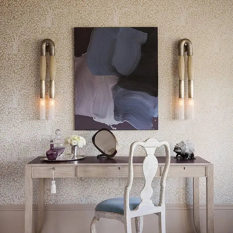 A vintage-style white wooden chair with light blue upholstered seat complements modern gold and silver decorbites designer tassel wall lamp