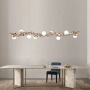 Modern gold and silver decorbites dimmable led hanging pendant light with metallic spheres and frosted orbs above dining table