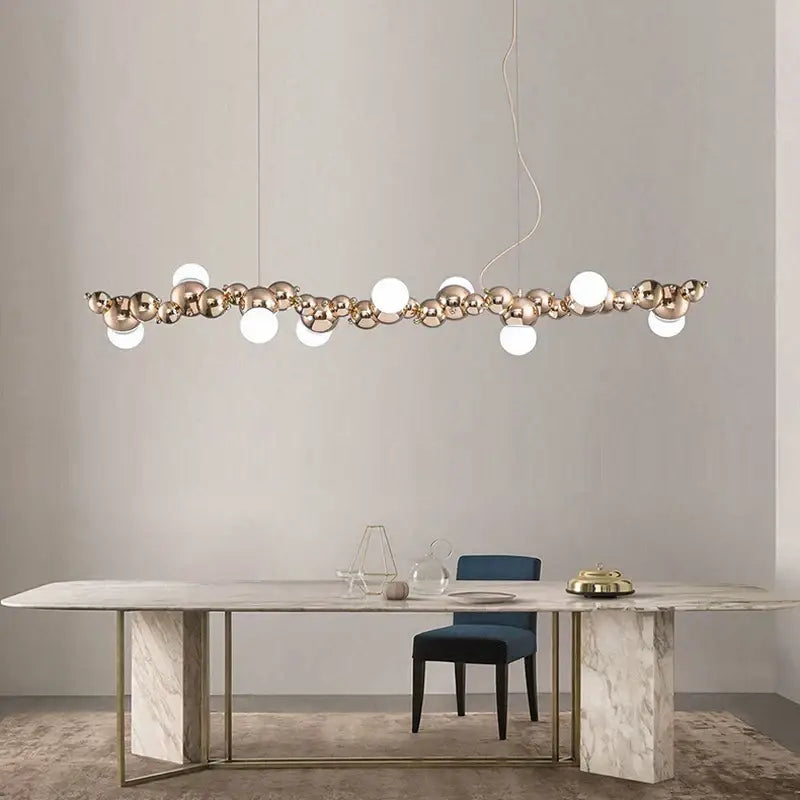 Modern gold and silver decorbites dimmable led hanging pendant light with metallic spheres and frosted orbs above dining table